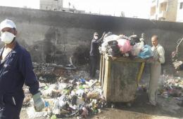 Activists clean up the perimeter of Neirab refugee camp in Aleppo